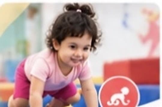 Young children practising basic gymnastics movements on mats